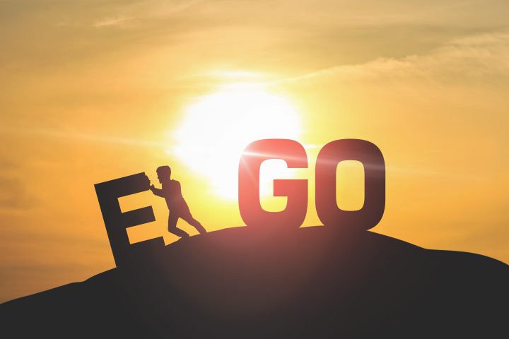 Silhouette of man push EGO with sky and sun light background.